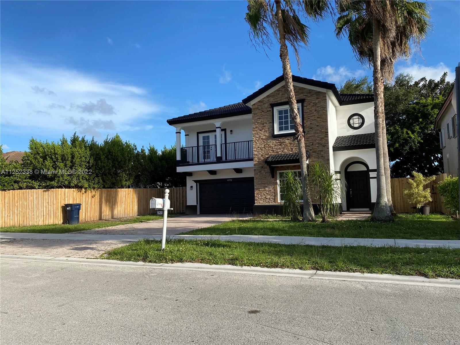 16350 Southwest 50th Terrace Miami, FL 33185 - Photo 2 of 59 a front view of a house with a garden and trees
