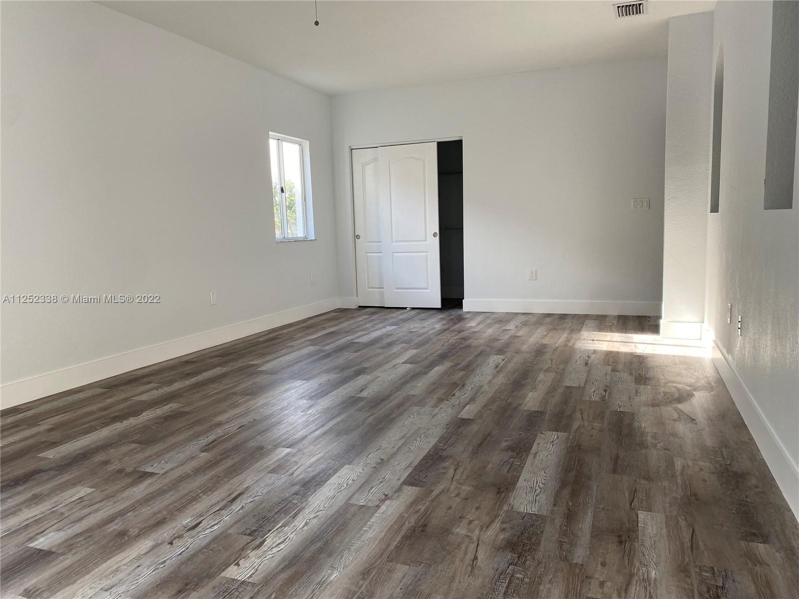 16350 Southwest 50th Terrace Miami, FL 33185 - Photo 23 of 59 a view of an empty room with wooden floor and a window