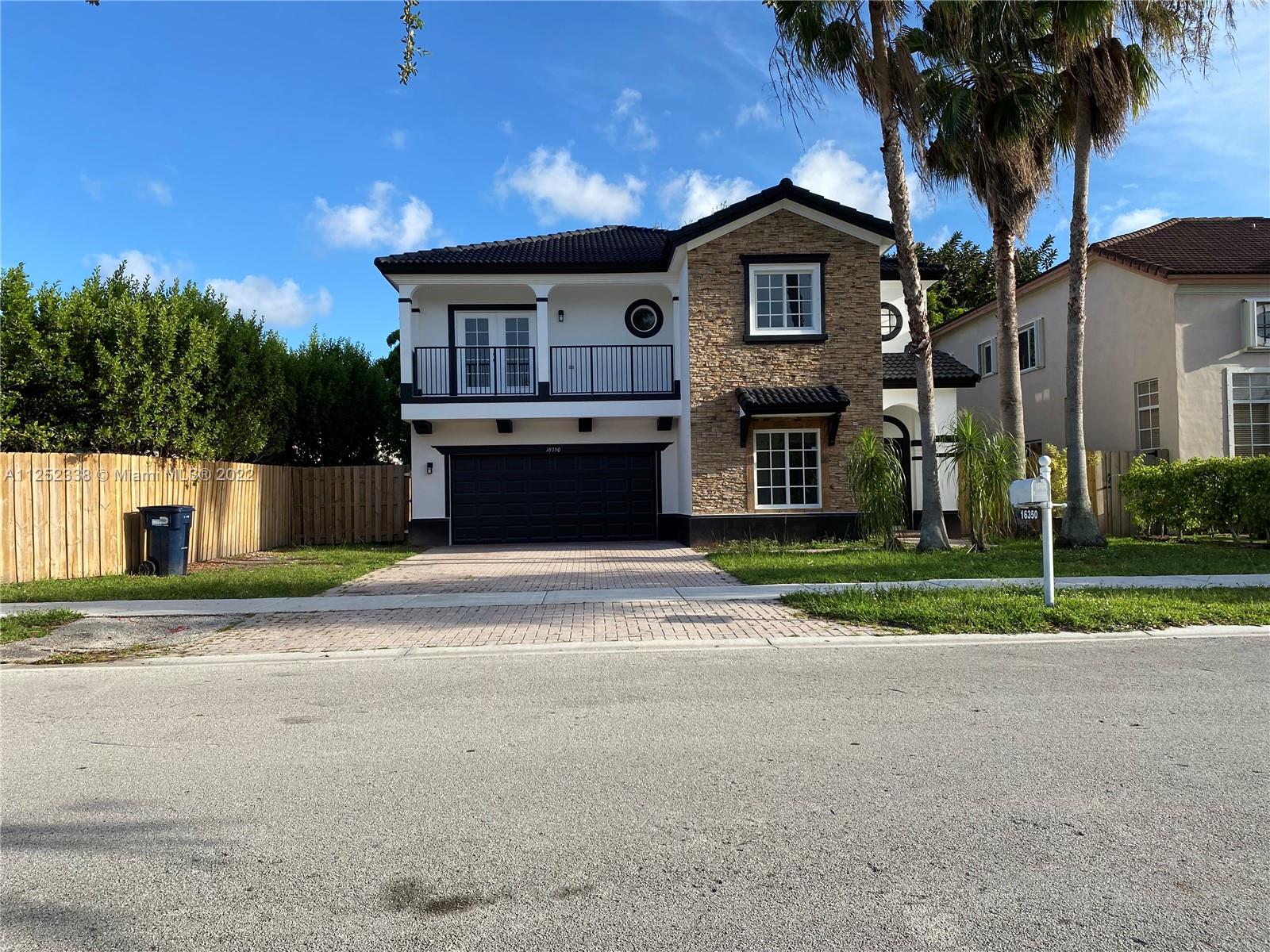 16350 Southwest 50th Terrace Miami, FL 33185 - Photo 3 of 59 a front view of a house with a garden and trees