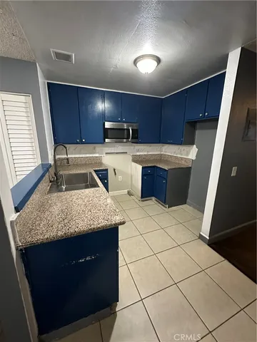 a kitchen with a sink a stove a microwave and cabinets