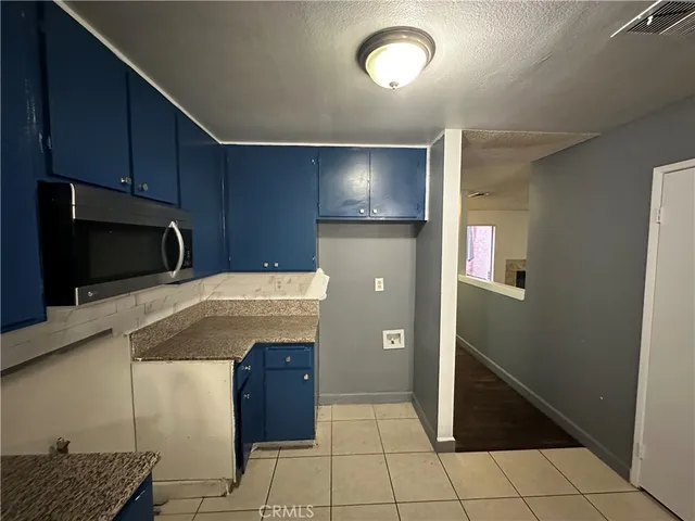 a kitchen with granite countertop a refrigerator and a stove top oven