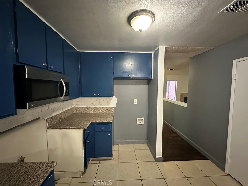165 Racquet Club Drive Compton, CA 90220 - Photo 15 of 47 a kitchen with granite countertop a refrigerator and a stove top oven