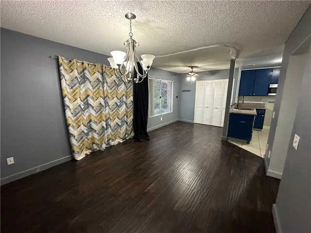 a view of a kitchen with wooden floor and a refrigerator