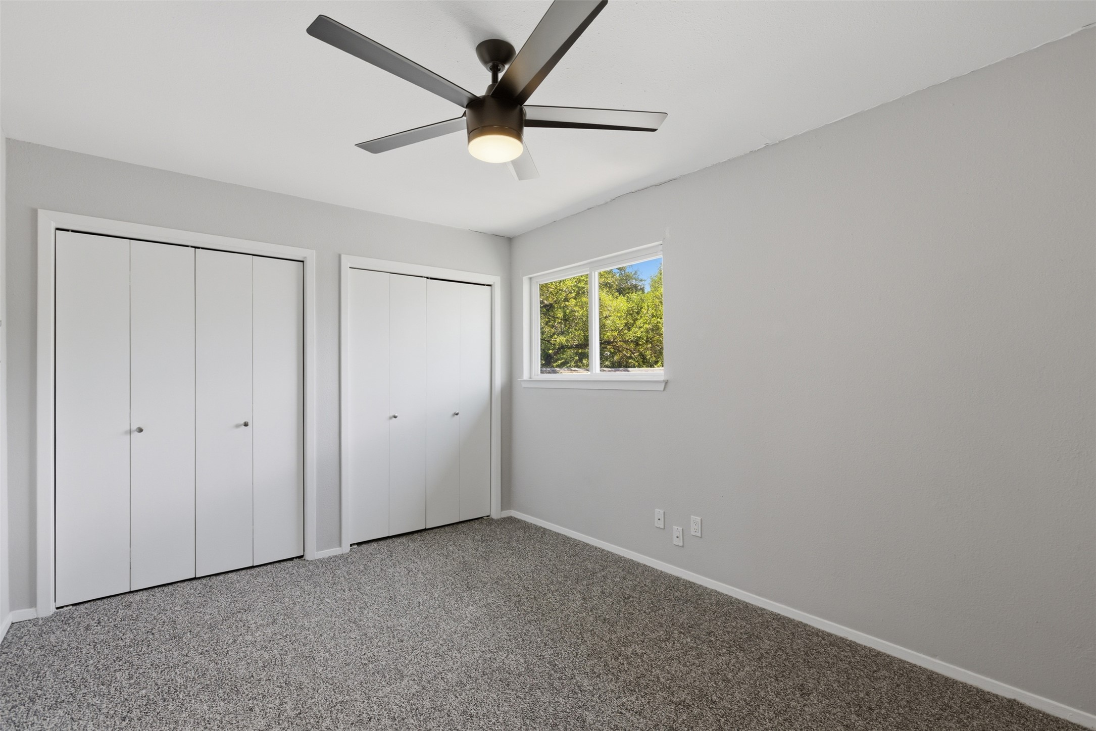 4204 Hudson Bend Road, Unit B Austin, TX 78734 - Photo 20 of 37 Room featuring neutral-toned carpeting, two bi-fold door closets, a single window, a ceiling fan with integrated lighting, and light gray wall paint