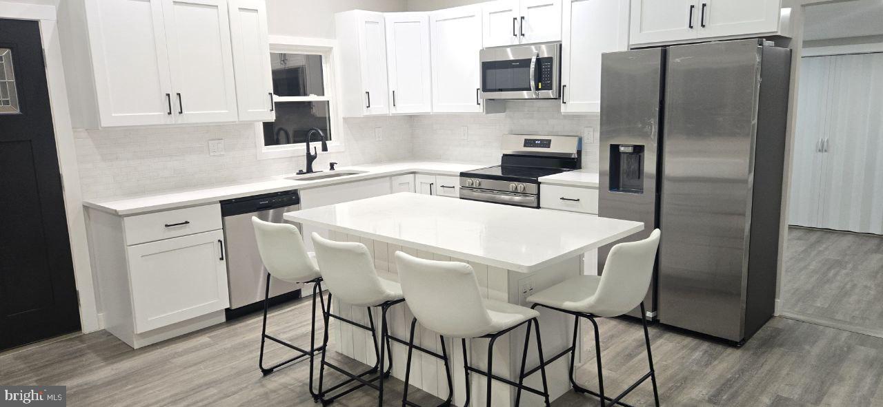 702 Beaumont Road Fairless Hills, PA 19030 - Photo 14 of 28 a kitchen with stainless steel appliances a table chairs microwave and refrigerator
