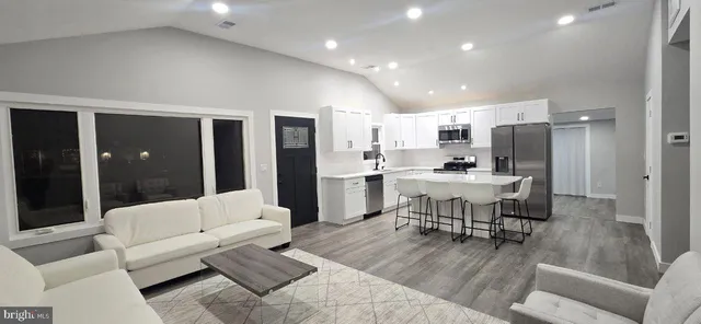 a living room with furniture and kitchen view