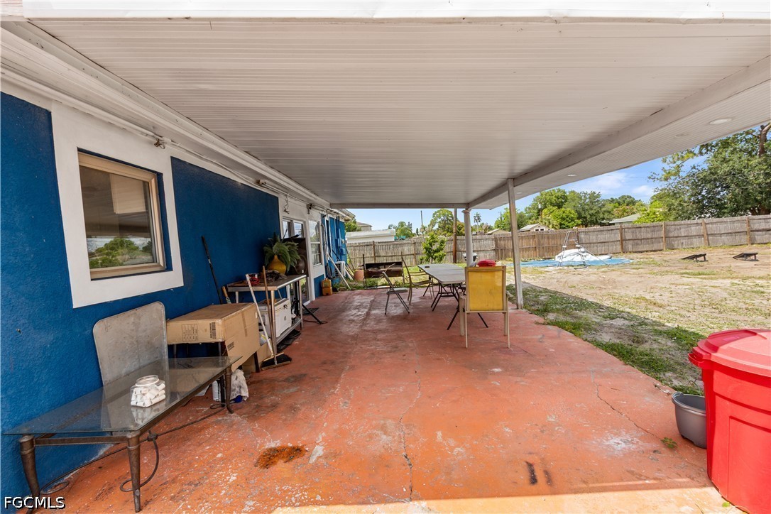 18 Illinois Road Lehigh Acres, FL 33936 - Photo 33 of 45 a view of a patio with table and chairs a barbeque with wooden fence