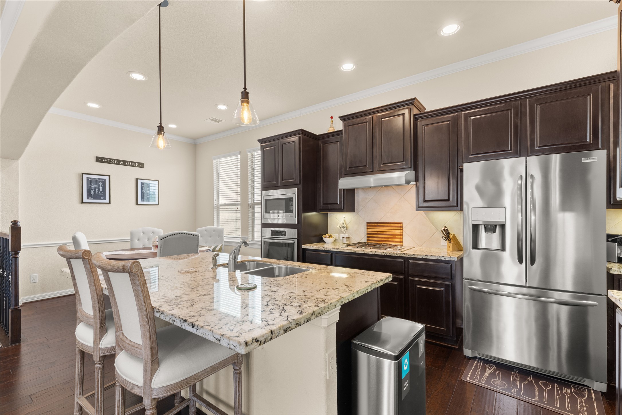 10204 Spring Shadows Park Circle Houston, TX 77080 - Photo 10 of 48 a kitchen with stainless steel appliances granite countertop a refrigerator a stove a kitchen island a dining table and chairs