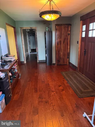 a view of a livingroom with wooden floor and a ceiling fan