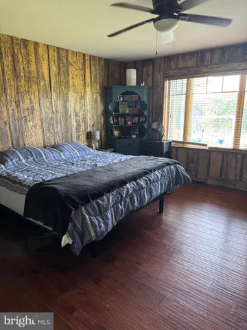 a bedroom with a large bed and wooden floor