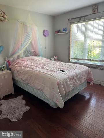 a bedroom with a bed dresser and a window