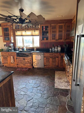 a kitchen with granite countertop a stove a sink and a microwave