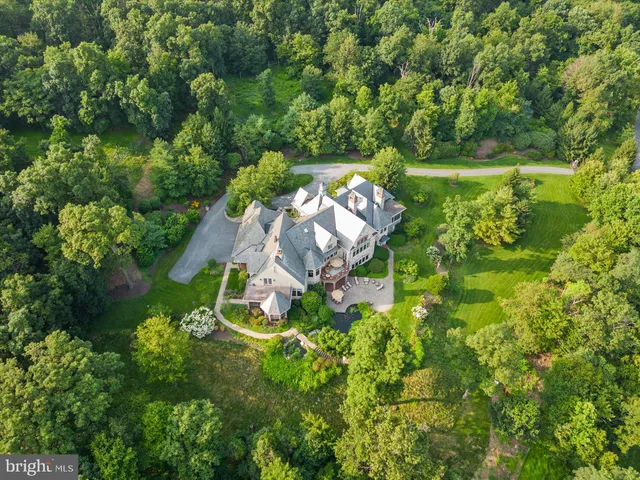 an aerial view of a house with a yard and lake view
