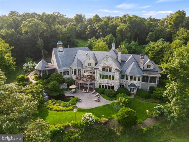 a living room with furniture a fireplace and large windows