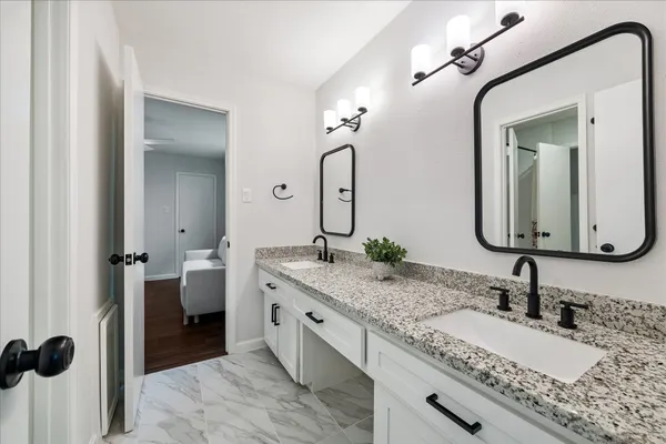 a bathroom with a granite countertop sink and a mirror