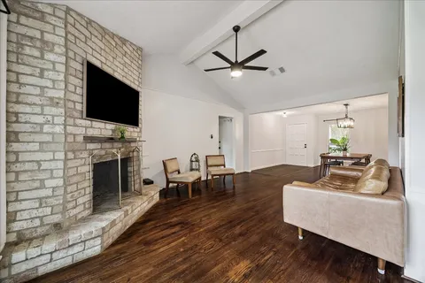 a living room with furniture a fireplace and a flat screen tv