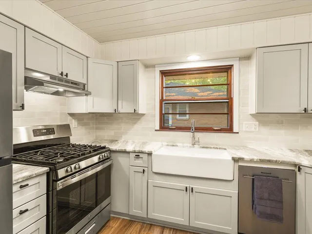 a kitchen with stainless steel appliances granite countertop a sink stove and cabinets