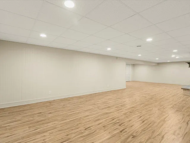 an empty room with wooden floor and entrance