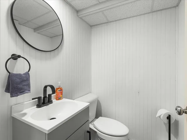 a bathroom with a sink mirror and toilet