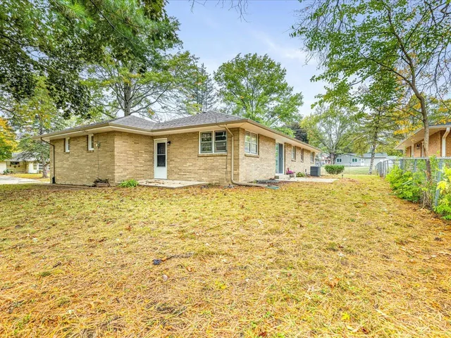 a front view of house with yard and trees around