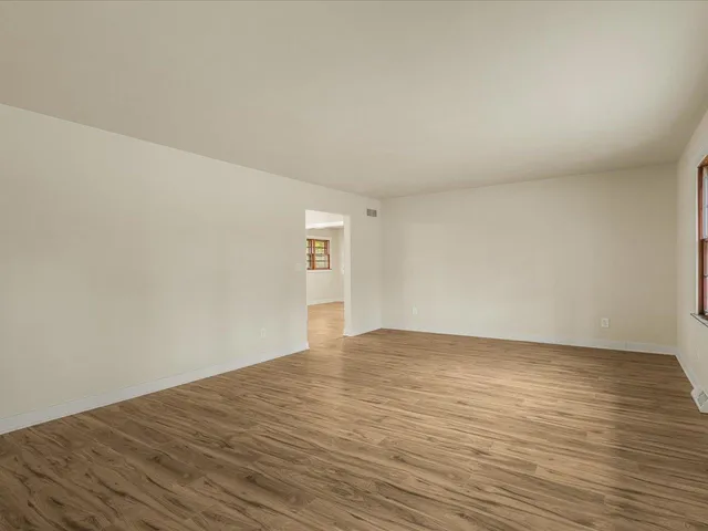 a view of an empty room and wooden floor