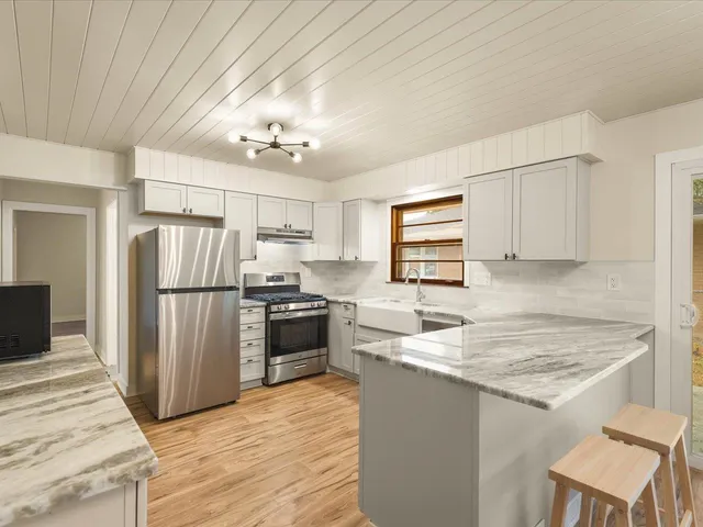 a kitchen with refrigerator cabinets and wooden floor