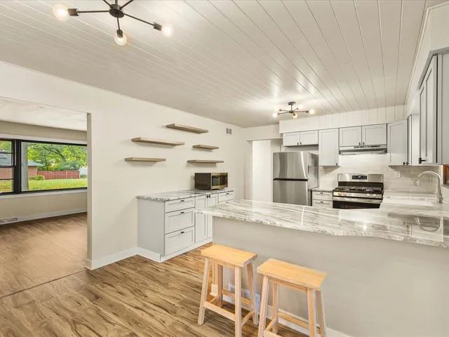 a kitchen with stainless steel appliances granite countertop a stove a sink and a refrigerator