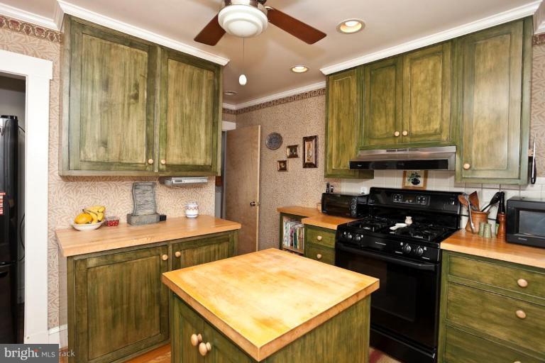 422 Kenneth Square Baltimore, MD 21212 - Photo 7 of 19 a kitchen with stainless steel appliances kitchen island granite countertop a stove refrigerator and cabinets