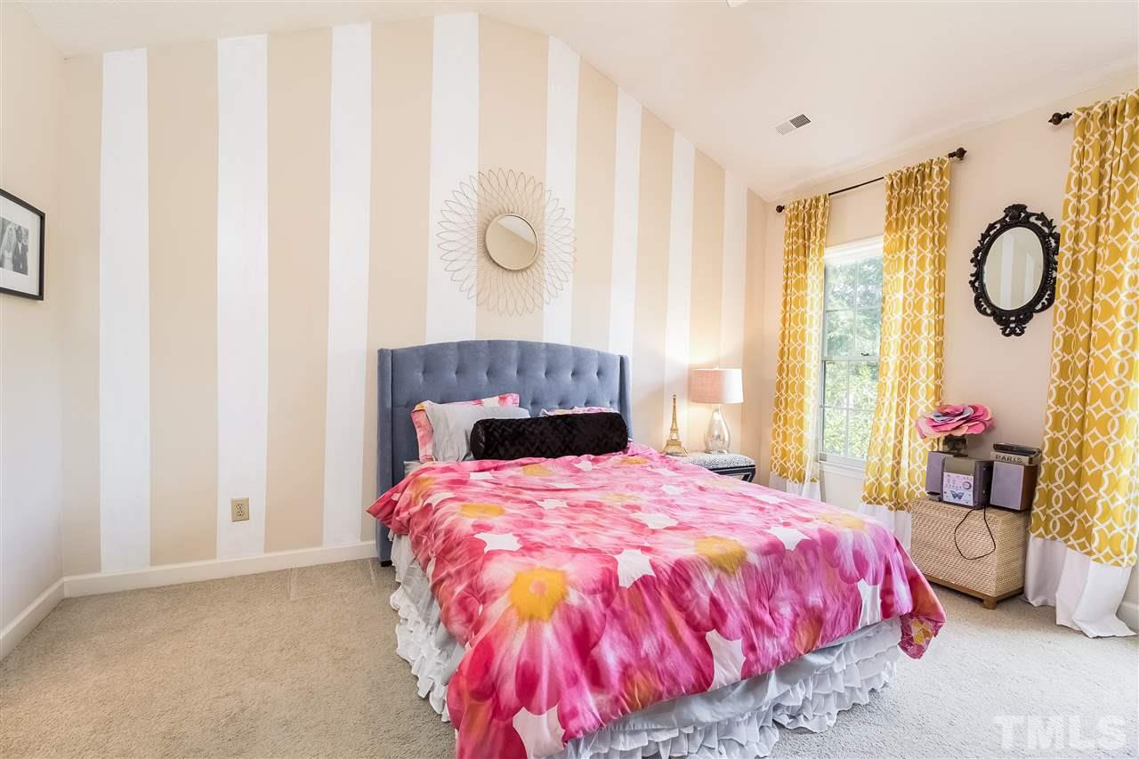 4201 Chelsford Place Raleigh, NC 27604 - Photo 12 of 24 a bed sitting in a bedroom next to a window and a chandelier