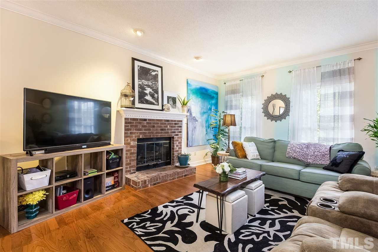 4201 Chelsford Place Raleigh, NC 27604 - Photo 3 of 24 a living room with furniture a flat screen tv and a fireplace
