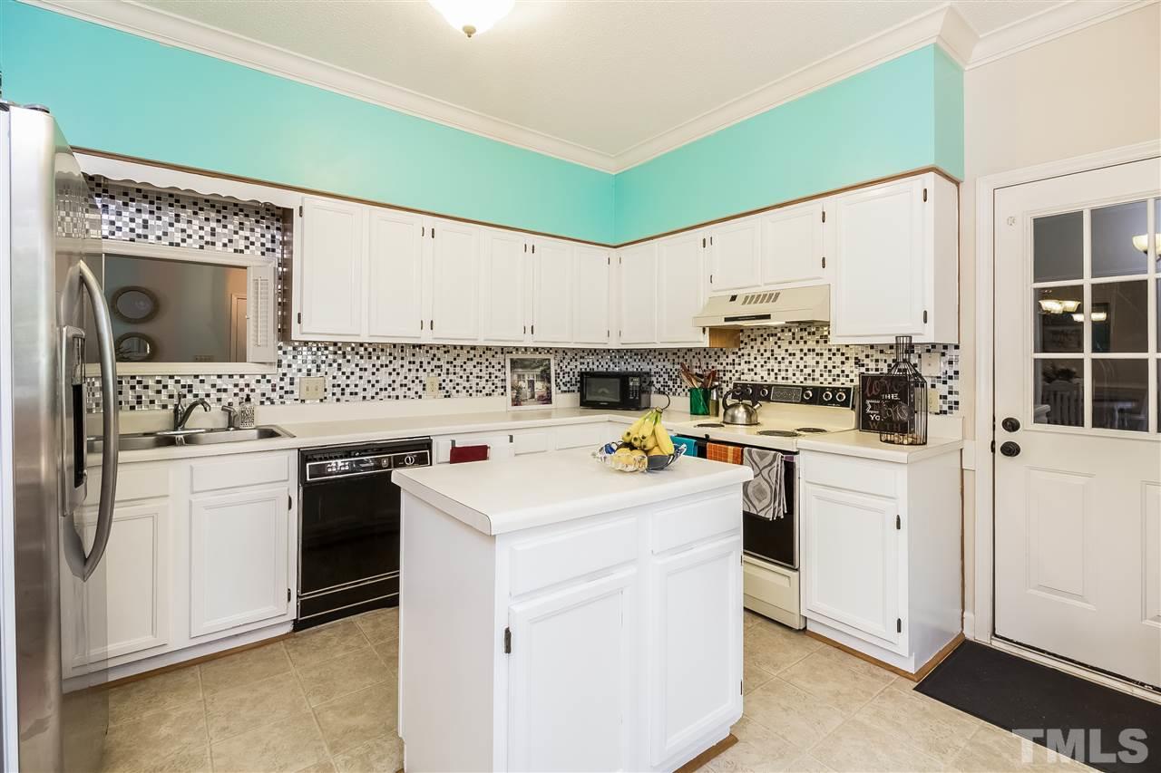 4201 Chelsford Place Raleigh, NC 27604 - Photo 7 of 24 a kitchen with sink a stove and white cabinets