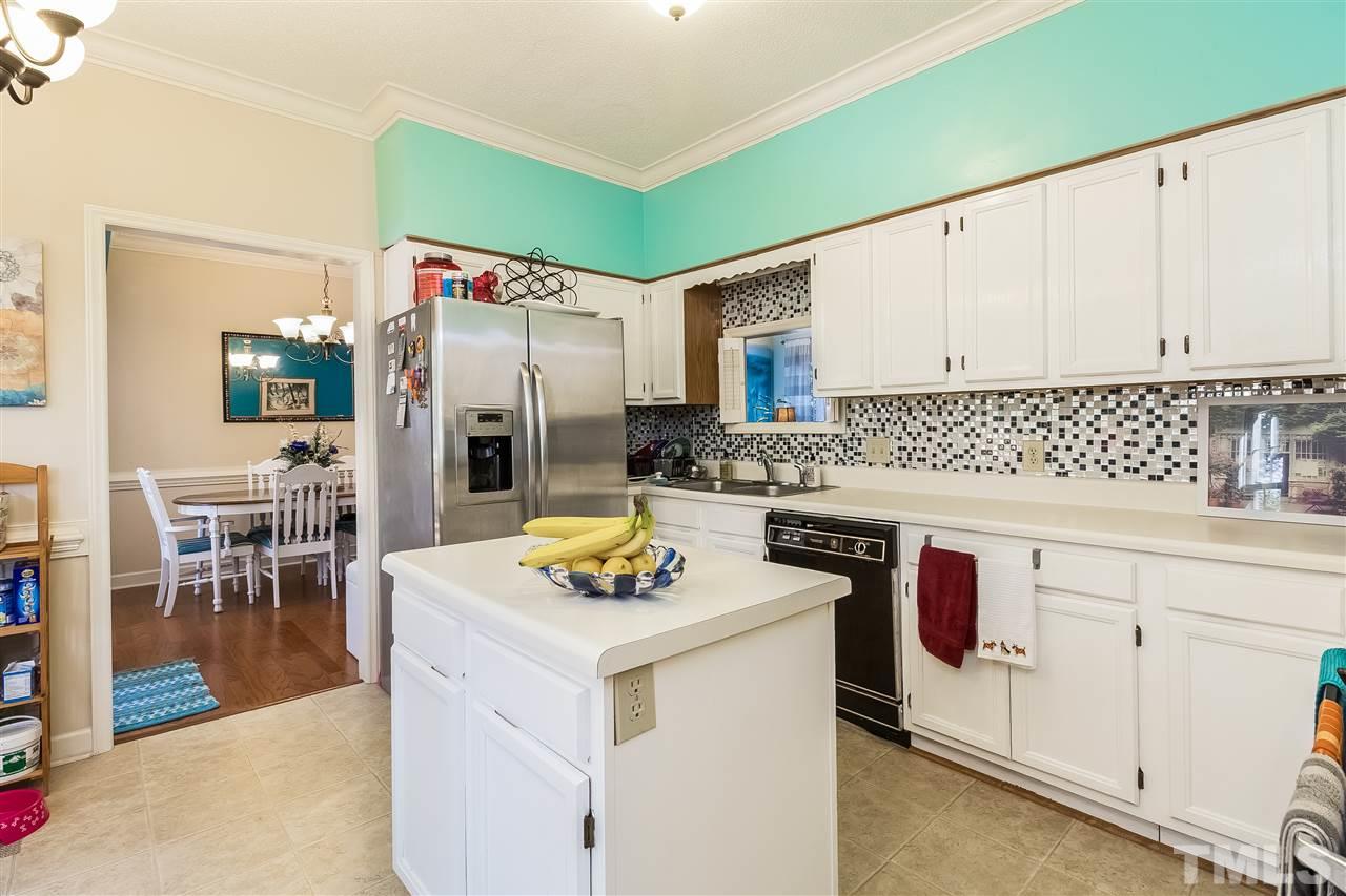 4201 Chelsford Place Raleigh, NC 27604 - Photo 8 of 24 a kitchen with granite countertop a sink stove and cabinets