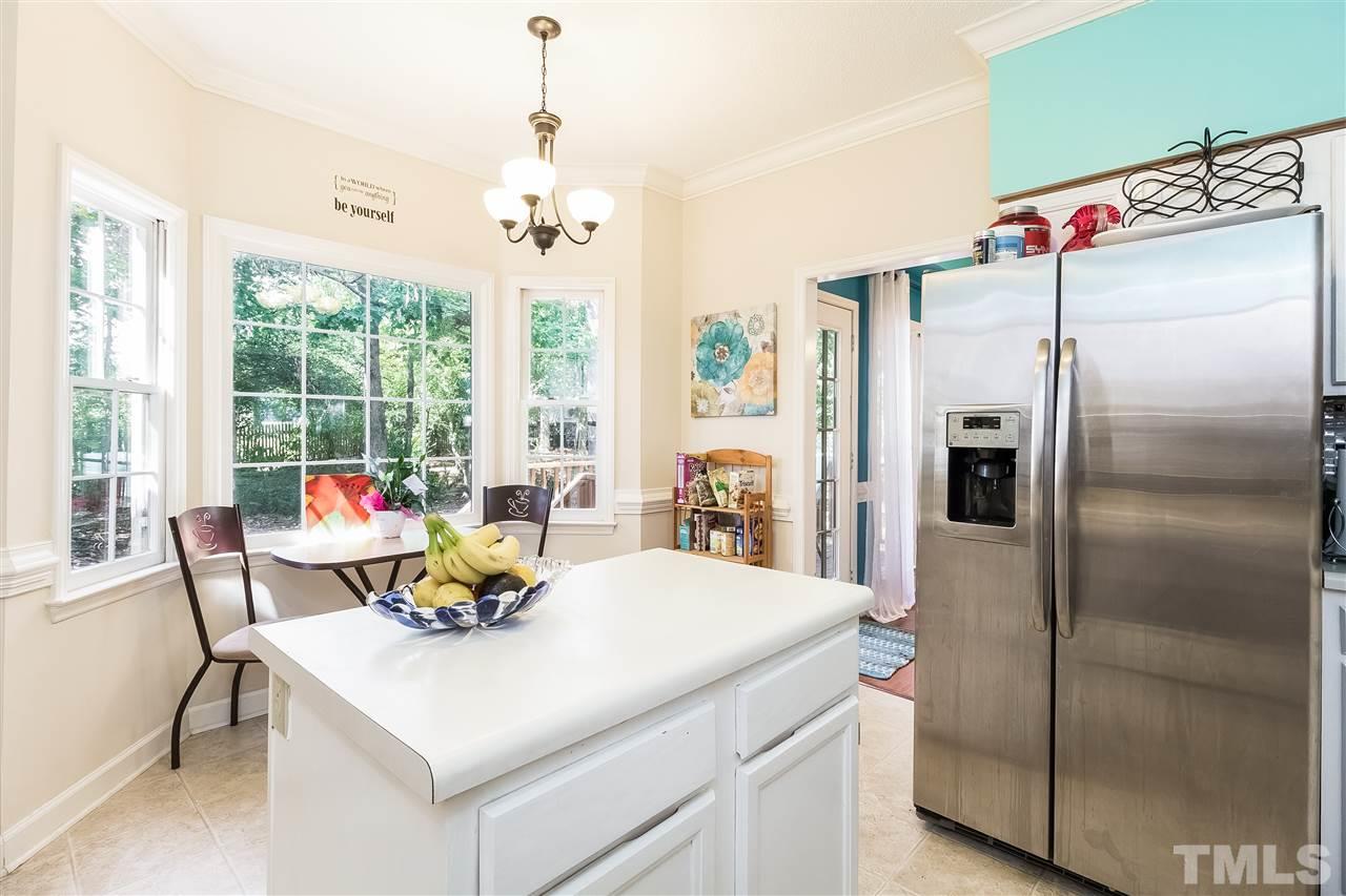 4201 Chelsford Place Raleigh, NC 27604 - Photo 9 of 24 a kitchen with a refrigerator a stove and a dining table