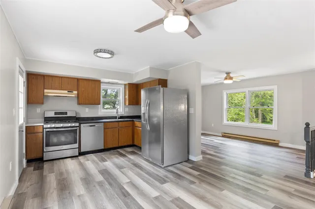 a kitchen with stainless steel appliances granite countertop a refrigerator a stove a sink and dishwasher