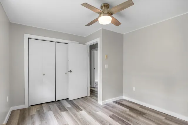an empty room with a ceiling fan and a window