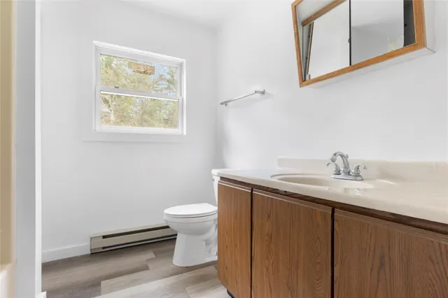 a bathroom with a granite countertop toilet sink and mirror