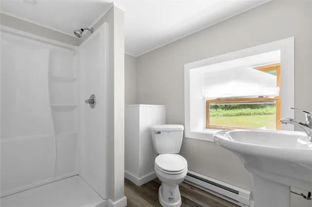 a bathroom with a toilet a sink and a large window