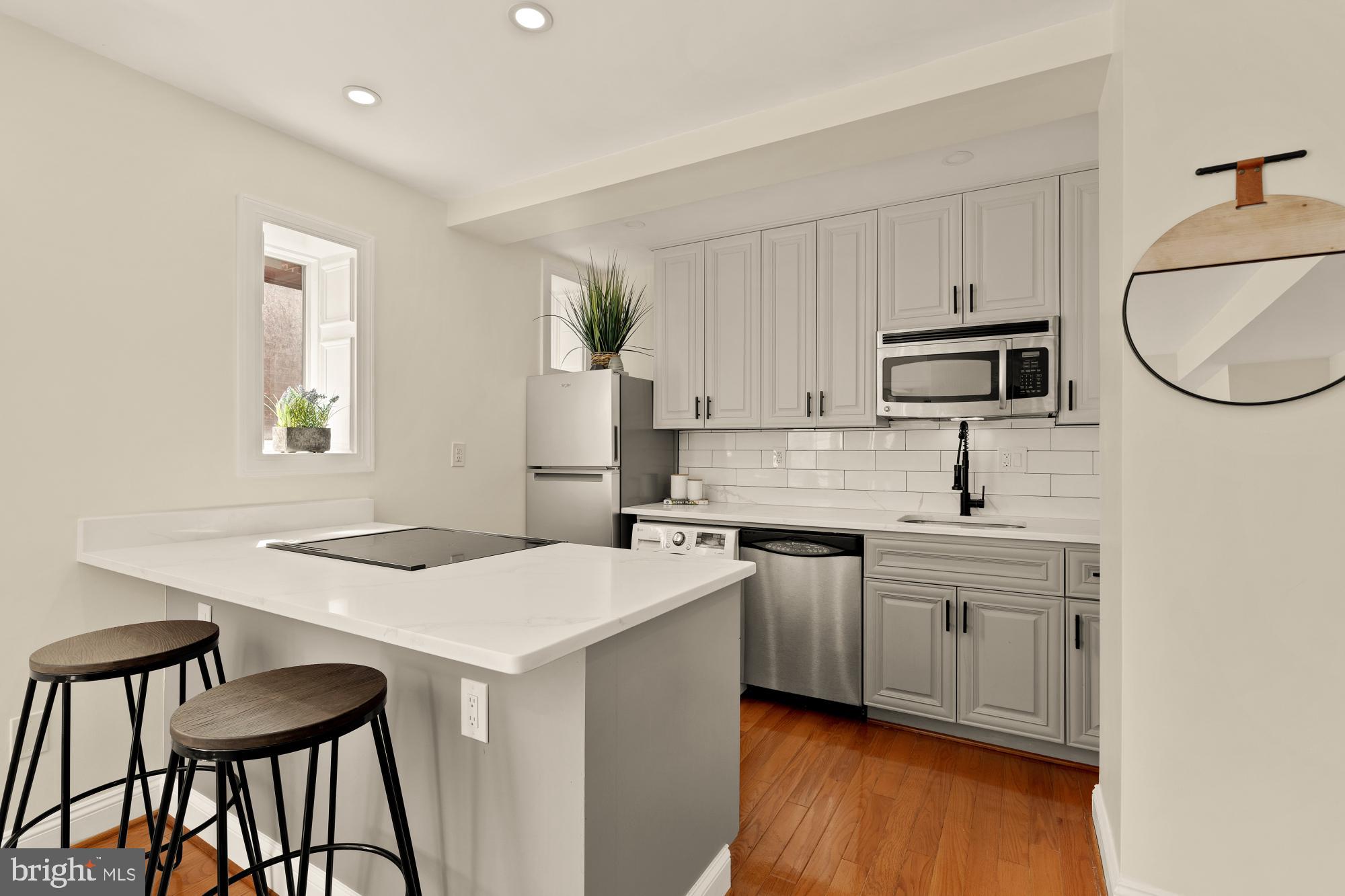 1125 12th Street Northwest, Unit 31 Washington, DC 20005 - Photo 13 of 25 a kitchen with a stove a sink and a refrigerator