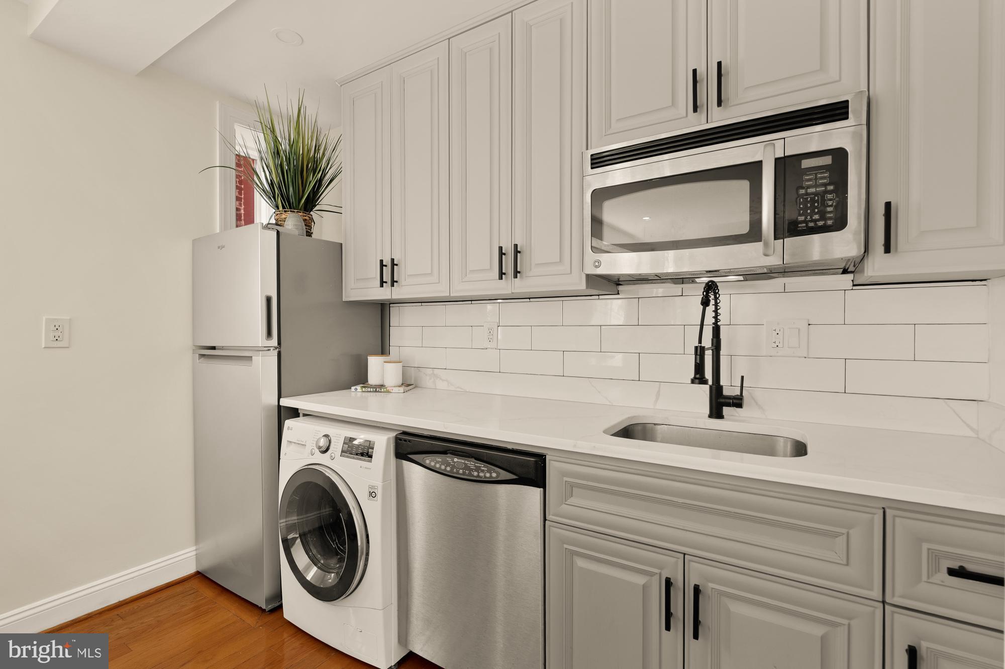 1125 12th Street Northwest, Unit 31 Washington, DC 20005 - Photo 15 of 25 a kitchen with appliances a sink and a microwave
