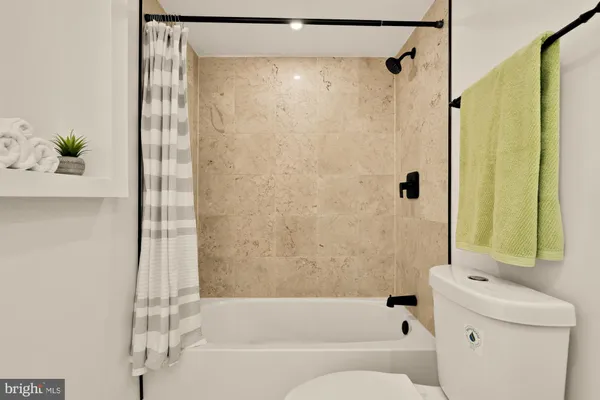 a bathroom with a bathtub shower and a sink