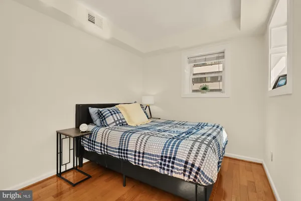 a bedroom with a bed and wooden floor