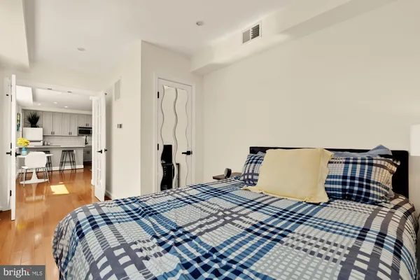 a bedroom with a bed and wooden floor