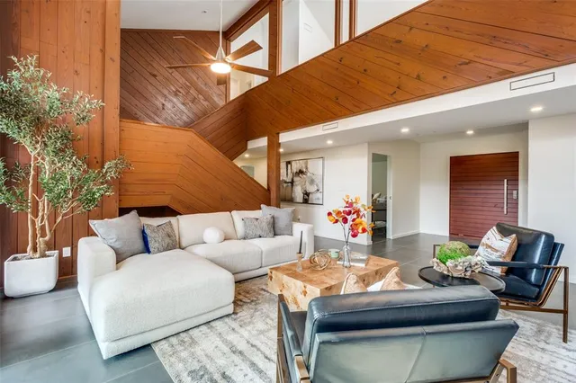 a living room with furniture and floor to ceiling windows