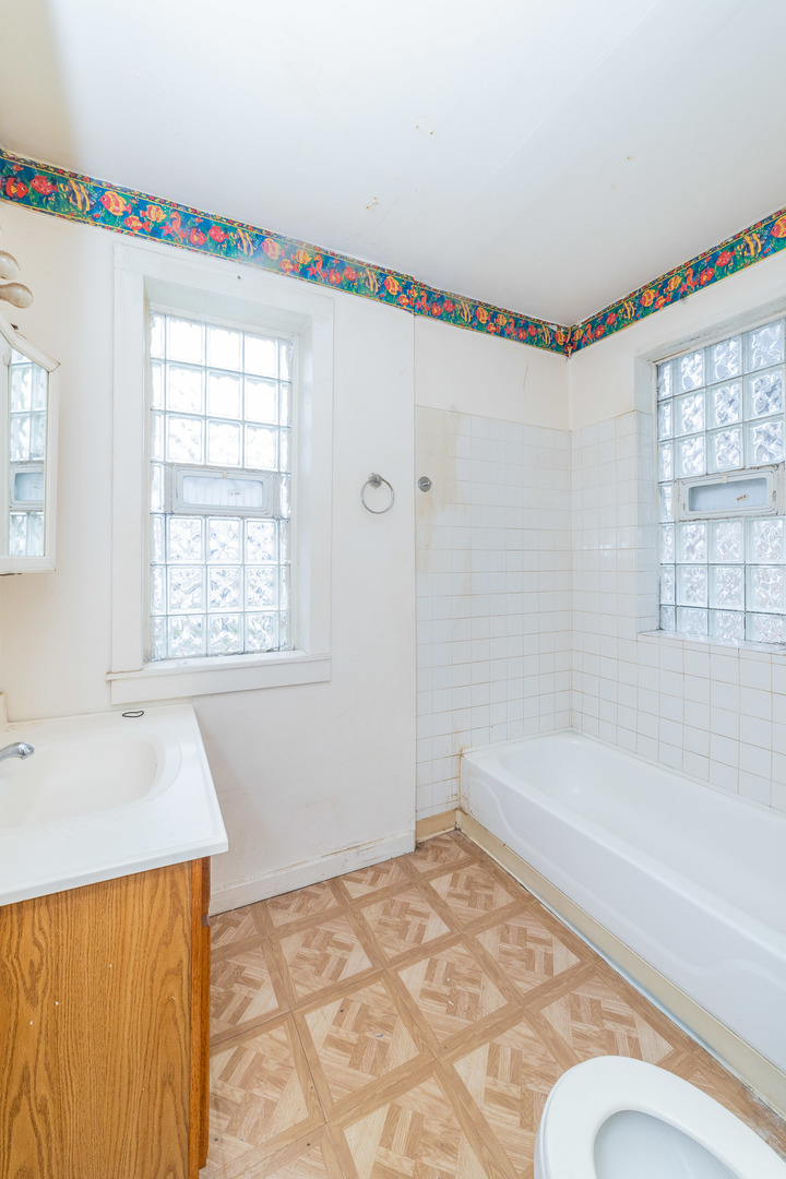 9154 South May Street Chicago, IL 60620 - Photo 15 of 40 a bathroom with a tub and a window