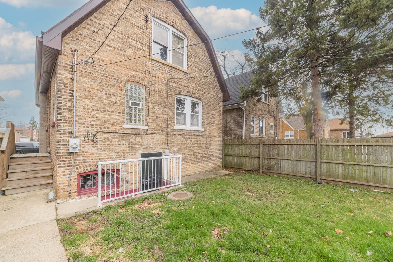 9154 South May Street Chicago, IL 60620 - Photo 39 of 40 a view of backyard with brick wall and a large tree