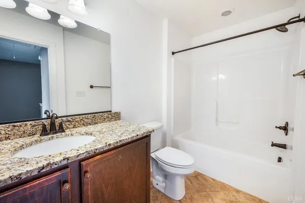 a kitchen with kitchen island granite countertop a sink stainless steel appliances and wooden floor