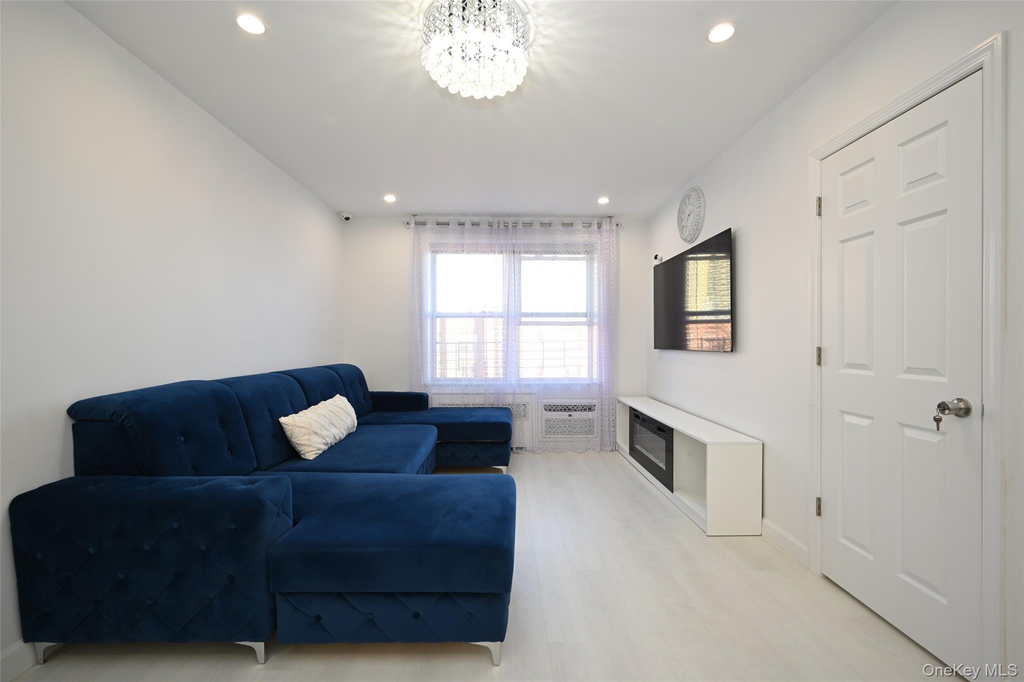 100-25 Queens Boulevard, Unit 7M Queens, NY 11375 - Photo 5 of 16 a living room with furniture and a chandelier