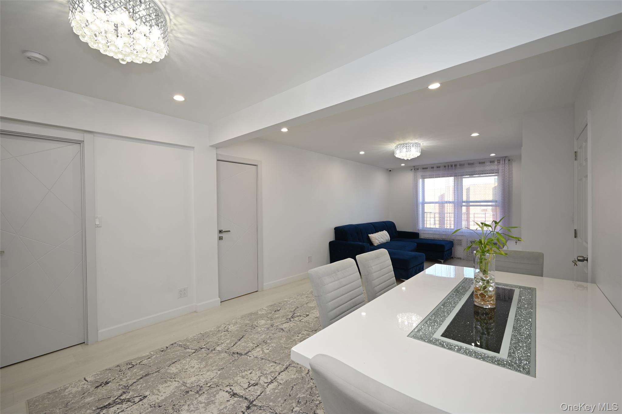 100-25 Queens Boulevard, Unit 7M Queens, NY 11375 - Photo 8 of 16 a living room with furniture and a chandelier