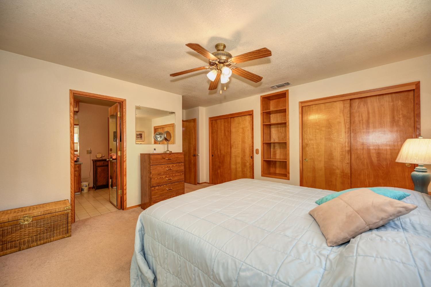 23998 Stable Road Sonora, CA 95370 - Photo 16 of 41 a bedroom with a large bed and a chandelier