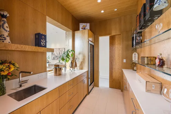 a kitchen with stainless steel appliances kitchen island a large counter top and a view of living room